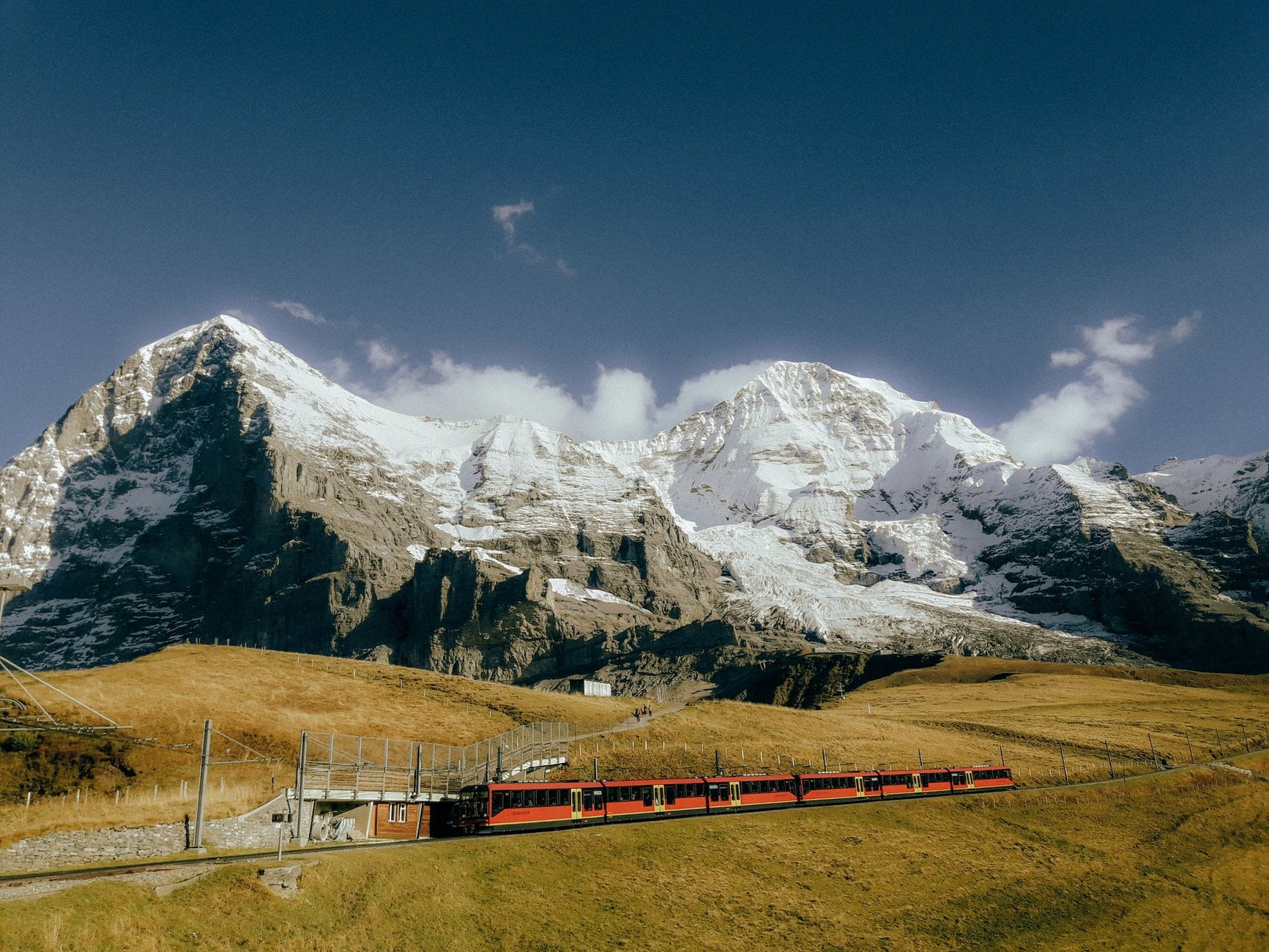 Czerwony pociąg Bernina Express jedzie przez ośnieżone Alpy