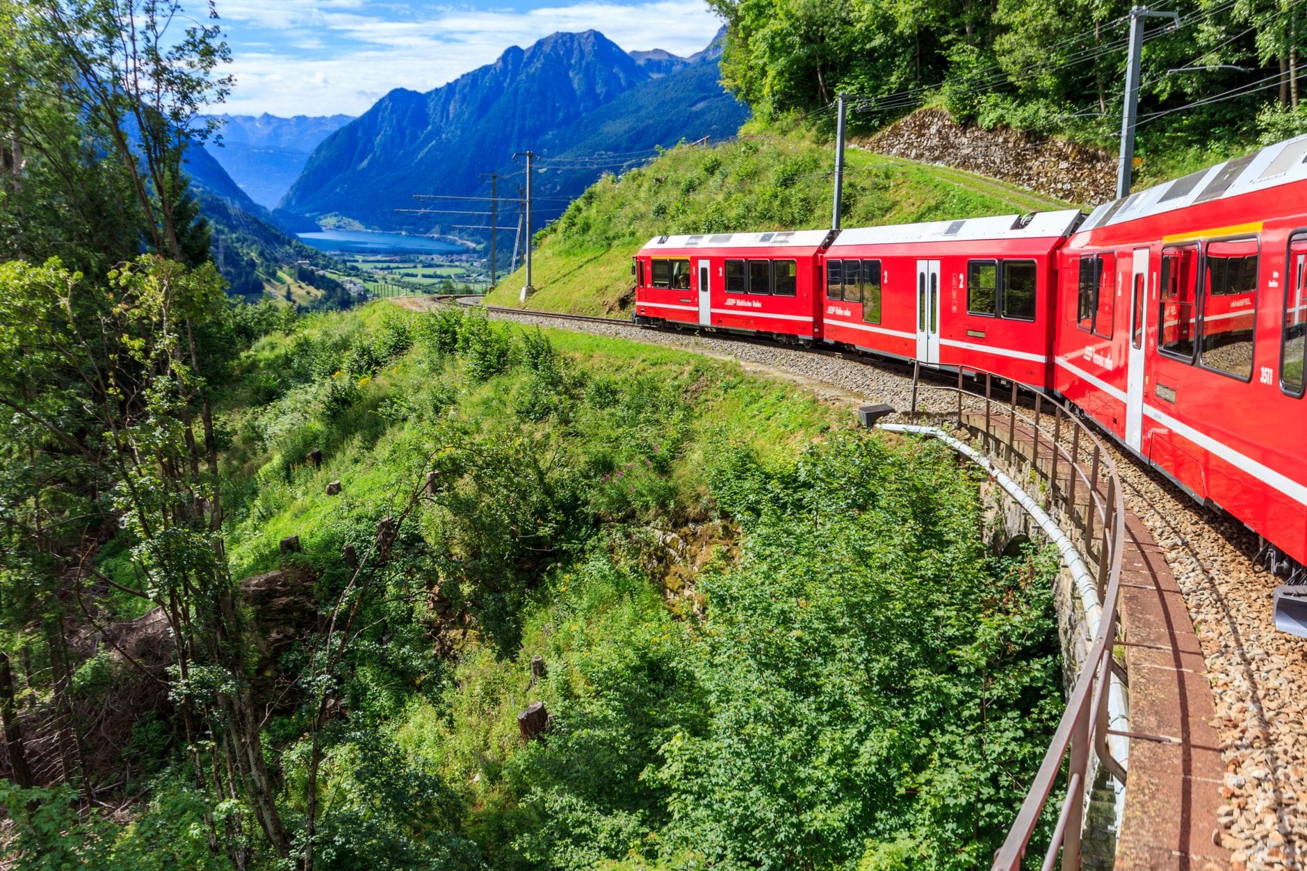 Pociąg Bernina Express jedzie pośród ośnieżonych Alp Szwajcarskich